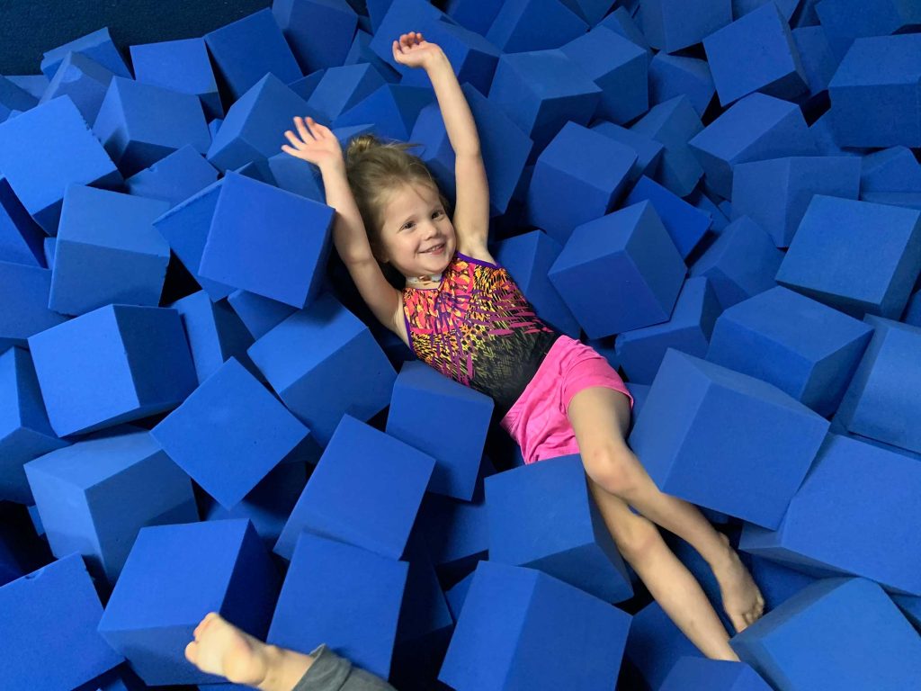 Preschool girl in a gymnastics landing pit